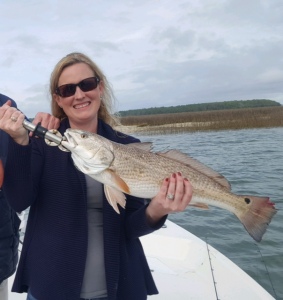 Devin Farr with a nice redfish caught under a popping cork with a mud minnow. Note damage on tail caused by a dolphin.