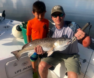 Scott McFaden & young son Elisha with large redfish. Nice job!