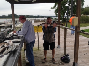 Tony with a seatrout and redfish nose to nose. NIce catch of fish in background.