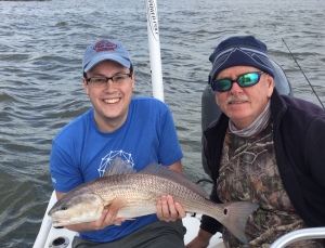 John Spencer Morris holding a nice red! He and Samantha caught some nice sea trout and reds on a windy day!