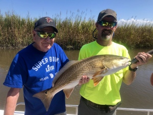 Lee & David Roper catching some reds & black drum. David is holding a large red.