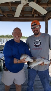 Capt. Jack is holding a couple of reds Isacc Pague caught.